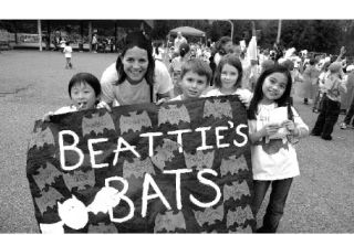 Members of Ashley Beattie’s third grade class at Snoqualmie Elementary School gather at their bat banner following the school’s walkathon on Thursday