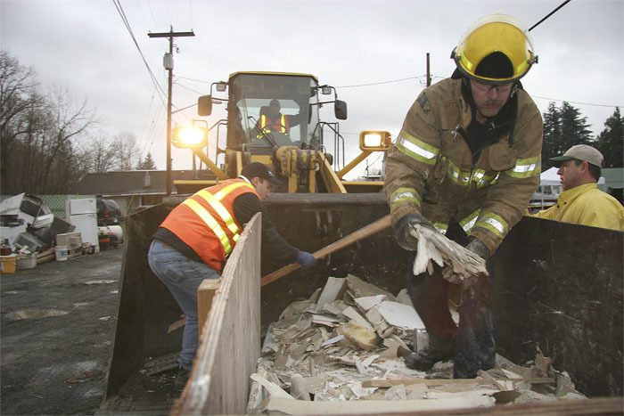 Firefighters and city of Snoqualmie Public Works crews haul flood debris during cleanup efforts in the wake of the 2009 flood. After a flood