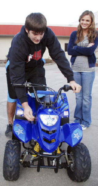 Mount Si High School student Brielle Buhner watches as Alex Bolves checks the starter apparatus for a four-wheel-drive