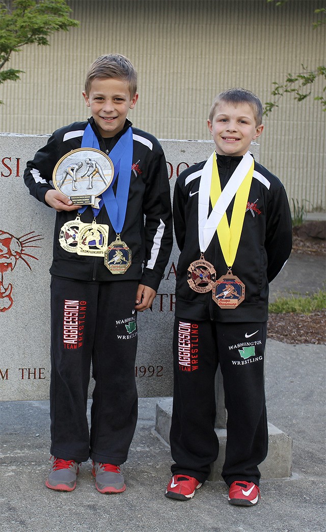 Showing off their hardware from the May 2-3 freestyle and Greco wrestling tournaments are Tryon Kaess and Benton Grisso.