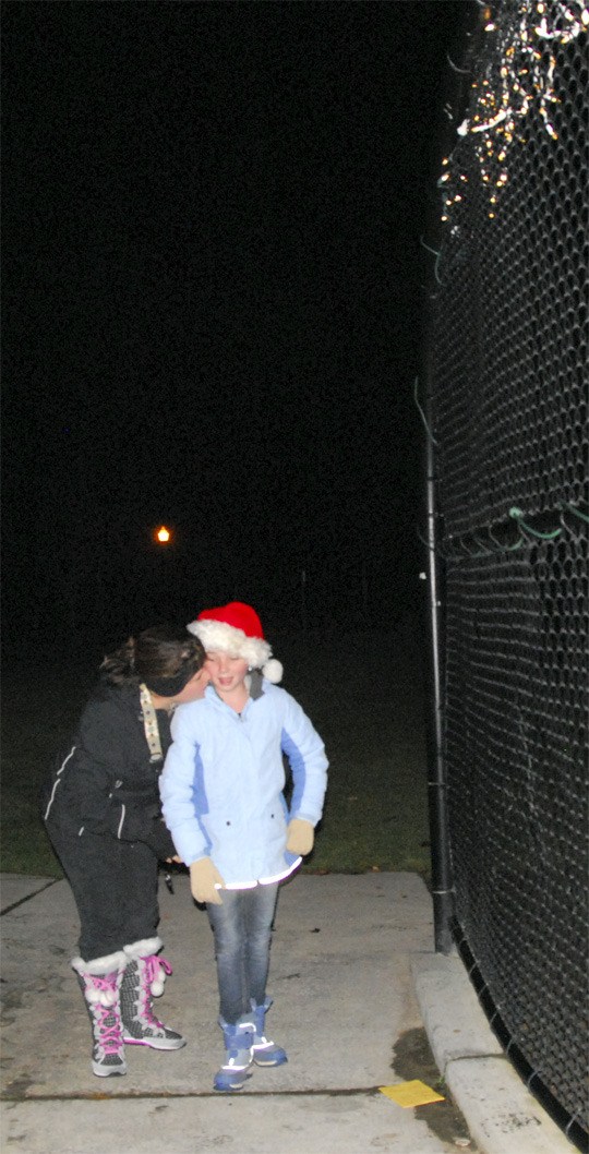 Lindsey Brown gets a hug from her Mom after the two light up the backdrop at Tanner Jeans field. Lindsey raised $1