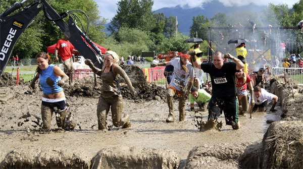 Contestants emerge from the final Warrior Dash mud crawl on July 15