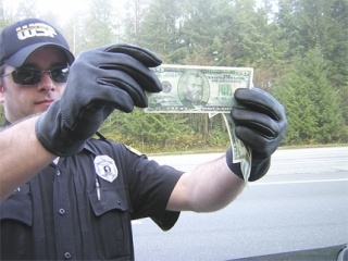 Washington State Trooper Chris Hooper holds up one of the soggy