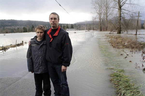 Jeff Groshell and his son Trevor inspect the flooded entrance to their family’s golf course at Fall City. Groshell was surprised by how high flood levels rose in the Lower Valley during the Martin Luther King Jr.