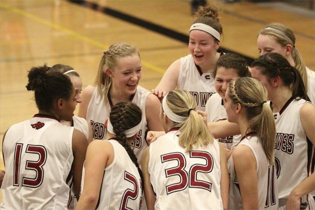 Cedarcrest's girls basketball team huddles during their home district game with Sehome. The team punched a historic state trip with their win Tuesday.