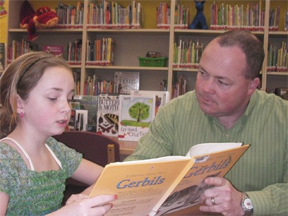 Cliff Brown reads with his daughter Lindsey at Cascade View Elementary. Brown