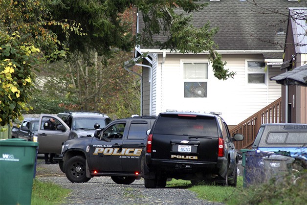 Police vehicles surround the downtown Snoqualmie apartment unit where a suspect in two armed robberies hid early Friday