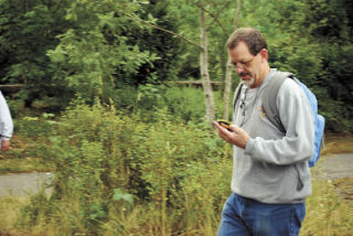 Bob Unruh uses a global positioning device on a family-oriented treasure hunt