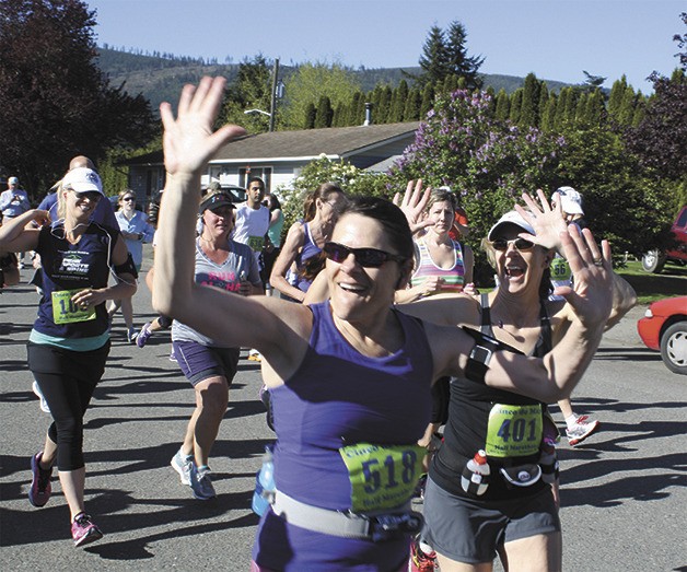 Participants Jo Ann Tracy of Pullman and Geri Pingul of Seattle wave to family members at the start of the half-marathon at the 2013 Cinco de Mayor fun run in Snoqualmie. The run returns this weekend.