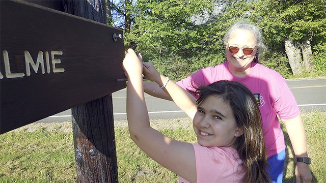 Troop leader Lyn Peck and Lingo put in sign bolts.