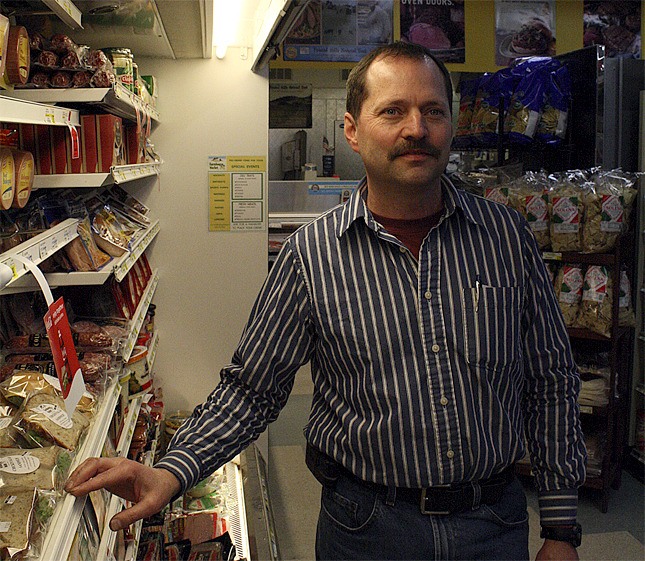 Farmhouse Market owner Jay Bluher visits his deli case. Bluher would like to be able to offer a hot deli