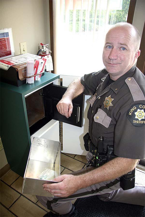 North Bend Police Chief Mark Toner opens the prescription drop box at the King County Sheriff’s substation. Valley police will accept and dispose of drugs on National Takeback Day.