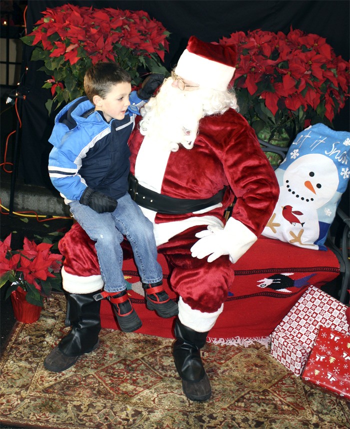 Santa Claus listens as William Tierney of North Bend shares holiday hopes at North Bend’s Holiday Festival