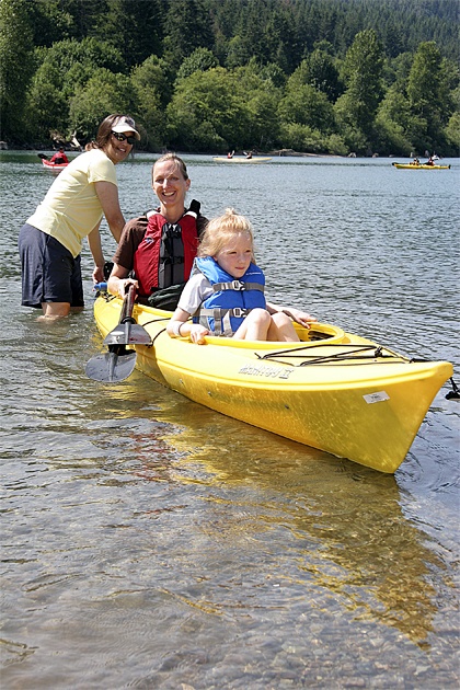 Volunteer Sarah Stewart helps mom Beth Bruels of Bellevue and daughter Grace