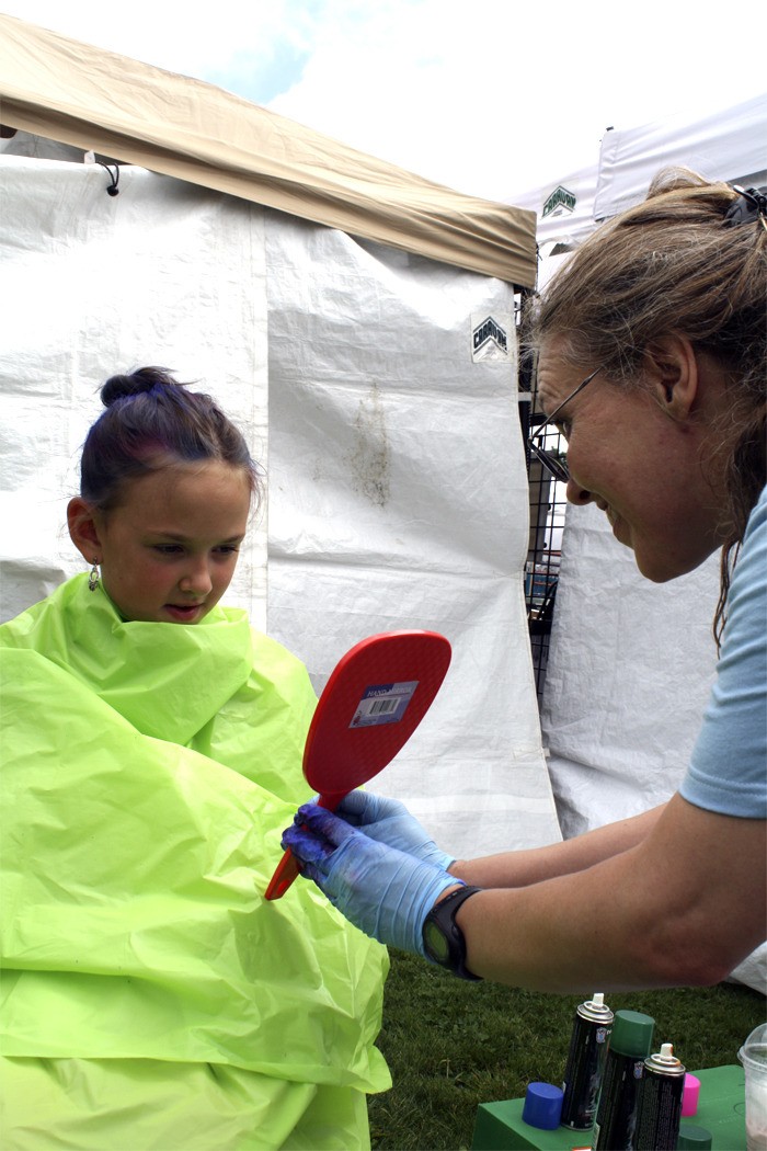 A young festival-goer checks out her new hairdo