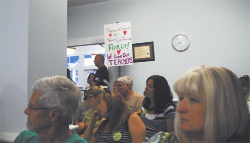 Teachers hold signs during the August 18 Snoqualmie Valley School District board meeting. Without movement in contract negotiations with the district Tuesday