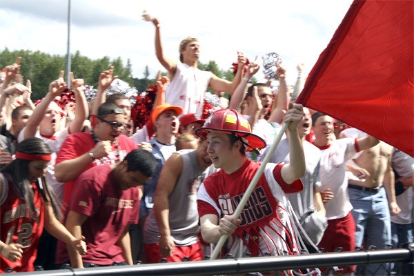 Tony Torchia parades the school flag across the Mount Si stadium in front of thousands of cheering schoolmates during lipdub filming.