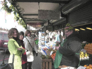 Produce vendor Brian Bright shares food samples and stories with tour participants Jan Meister and Linda Kaz