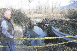 Snoqualmie resident and historian Dave Battey surveys the blown out embankment Thursday