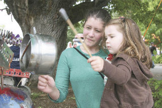 Banging on a pot that was part of the “junk chimes” display at the June 14 Fall City Days festival