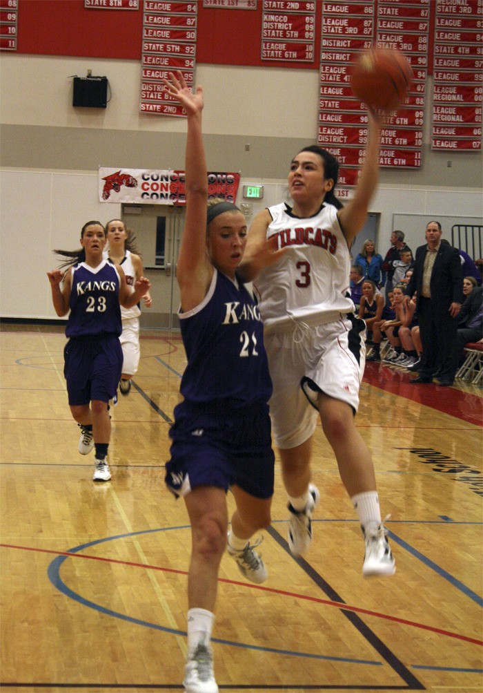 Mount Si junior Molly Sellers battles with Lake Washington guard Hunter Hopkins to send the ball downcourt during play Friday