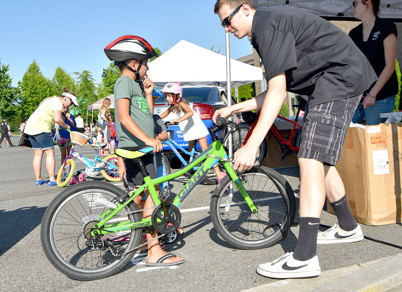 A youngster gets his bike tire pressure checked at the Singletrack tent Tuesday.                                (Carol Ladwig/Staff Photo)