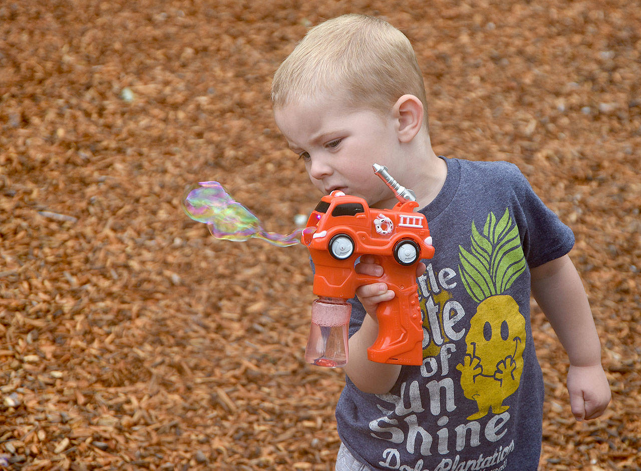 Robby Meidinger plays with a bubble gun Sunday at the Festival.                                (Carol Ladwig/Staff Photo)