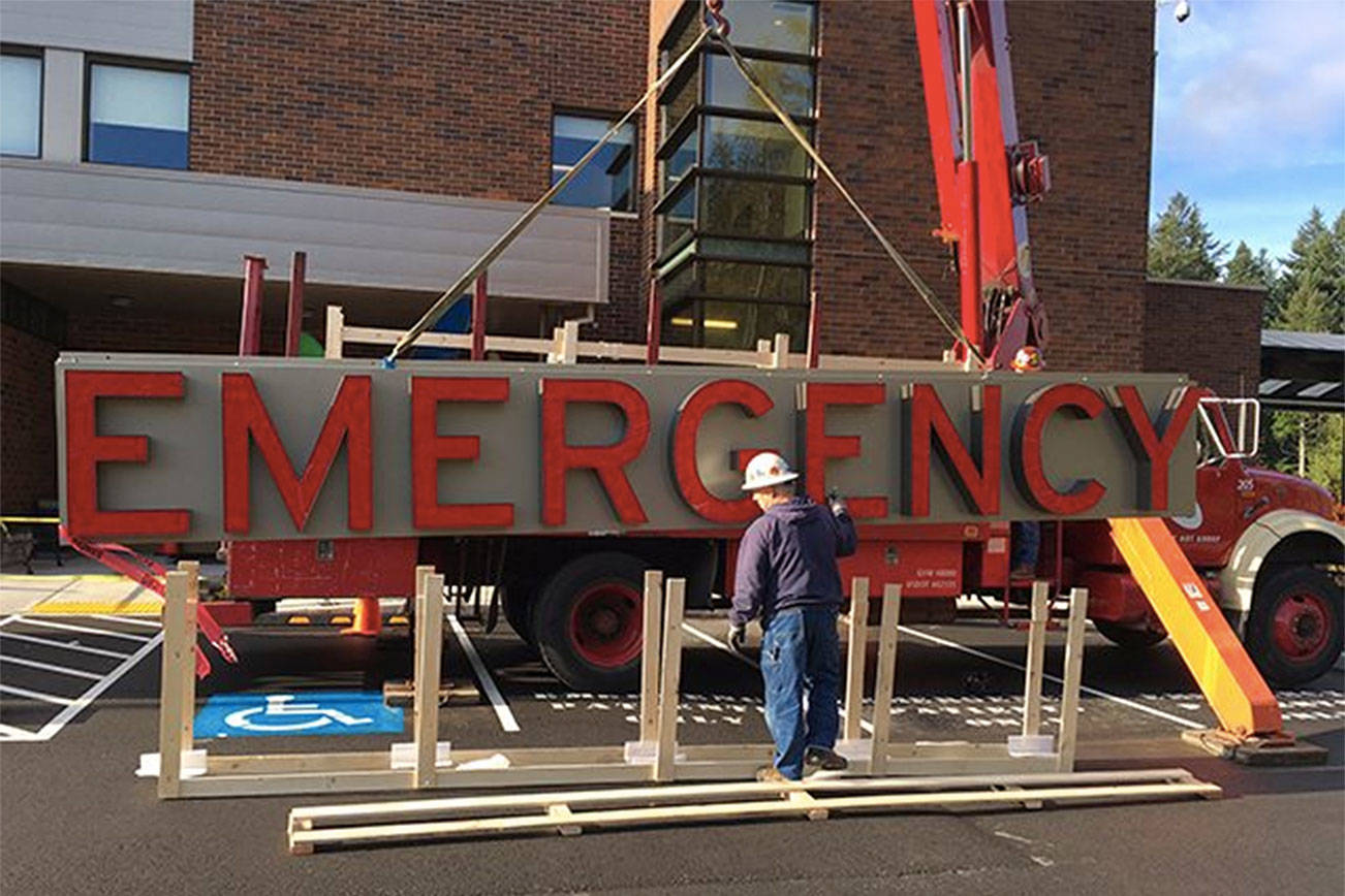 Workers install Snoqualmie Valley Hospital’s new Emergency Room sign in 2015. (Courtesy Photo)