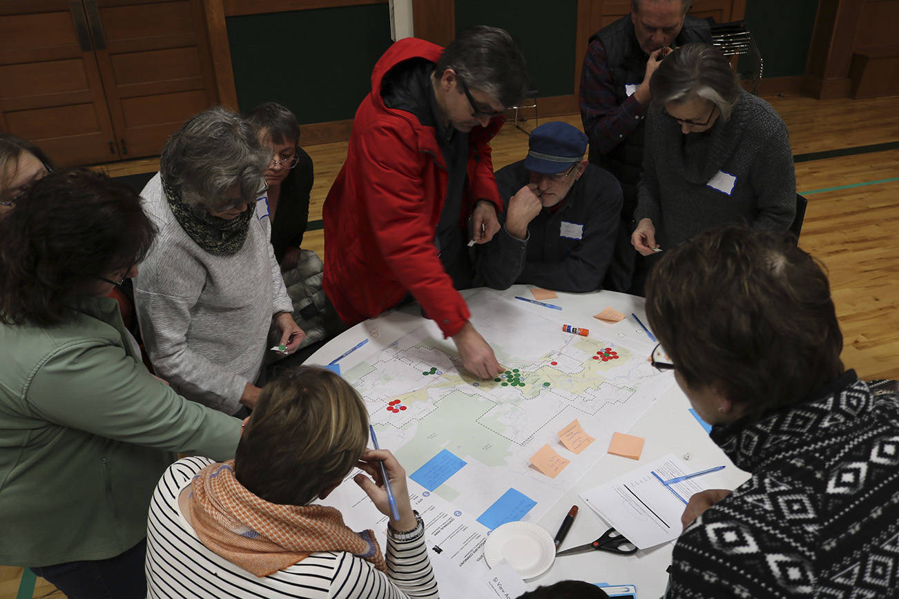 Community members gather around a map to discuss their opinions on where the future aquatics center should be located. Evan Pappas/Staff Photo