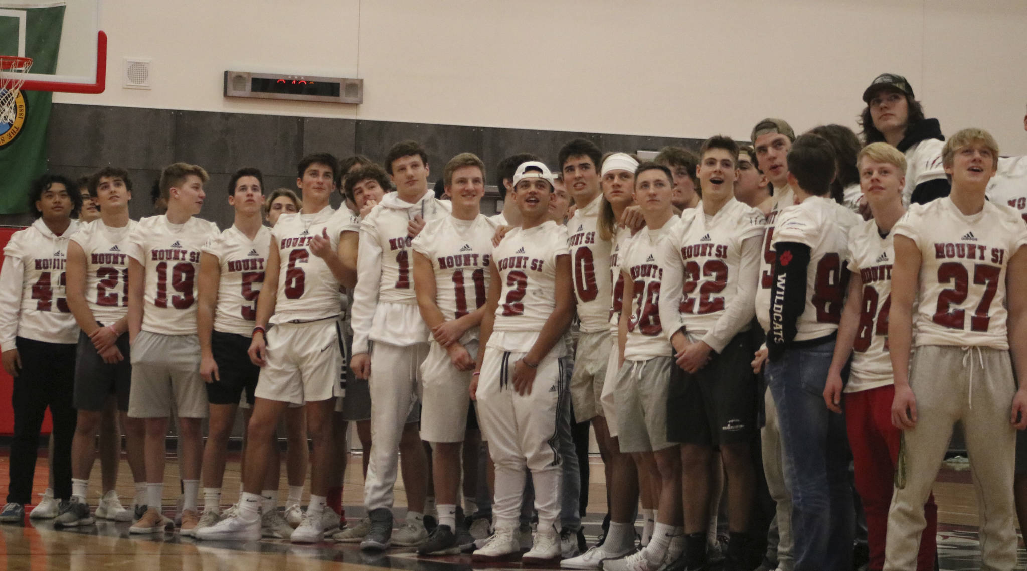 Members of the Mount Si football team watch a highlight montage from their 2019 season during halftime of the boys basketball game on Dec. 14.