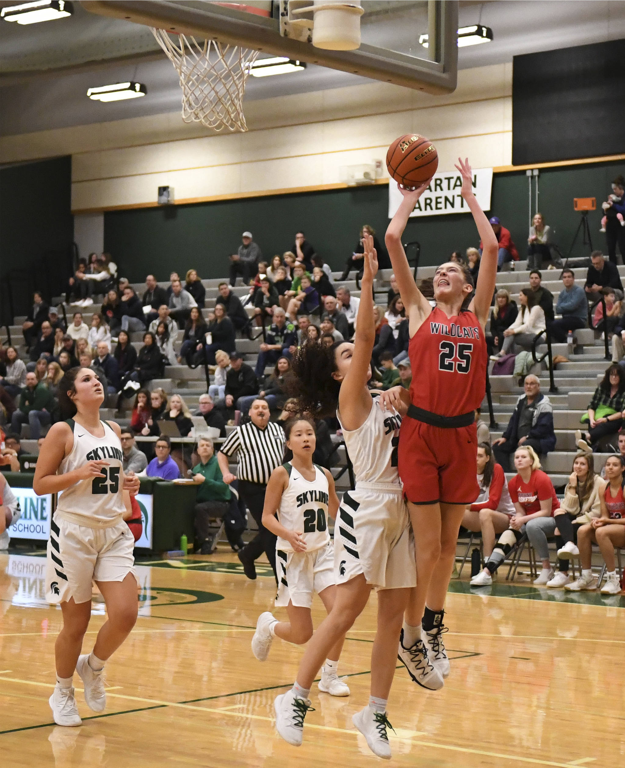 Mount Si sophomore forward Lauren Glazier (right) jumps over a Skyline defender during the Wildcats’ 41-18 victory over the Spartans on Jan. 3 at Skyline High School. Photo courtesy of Calder Productions