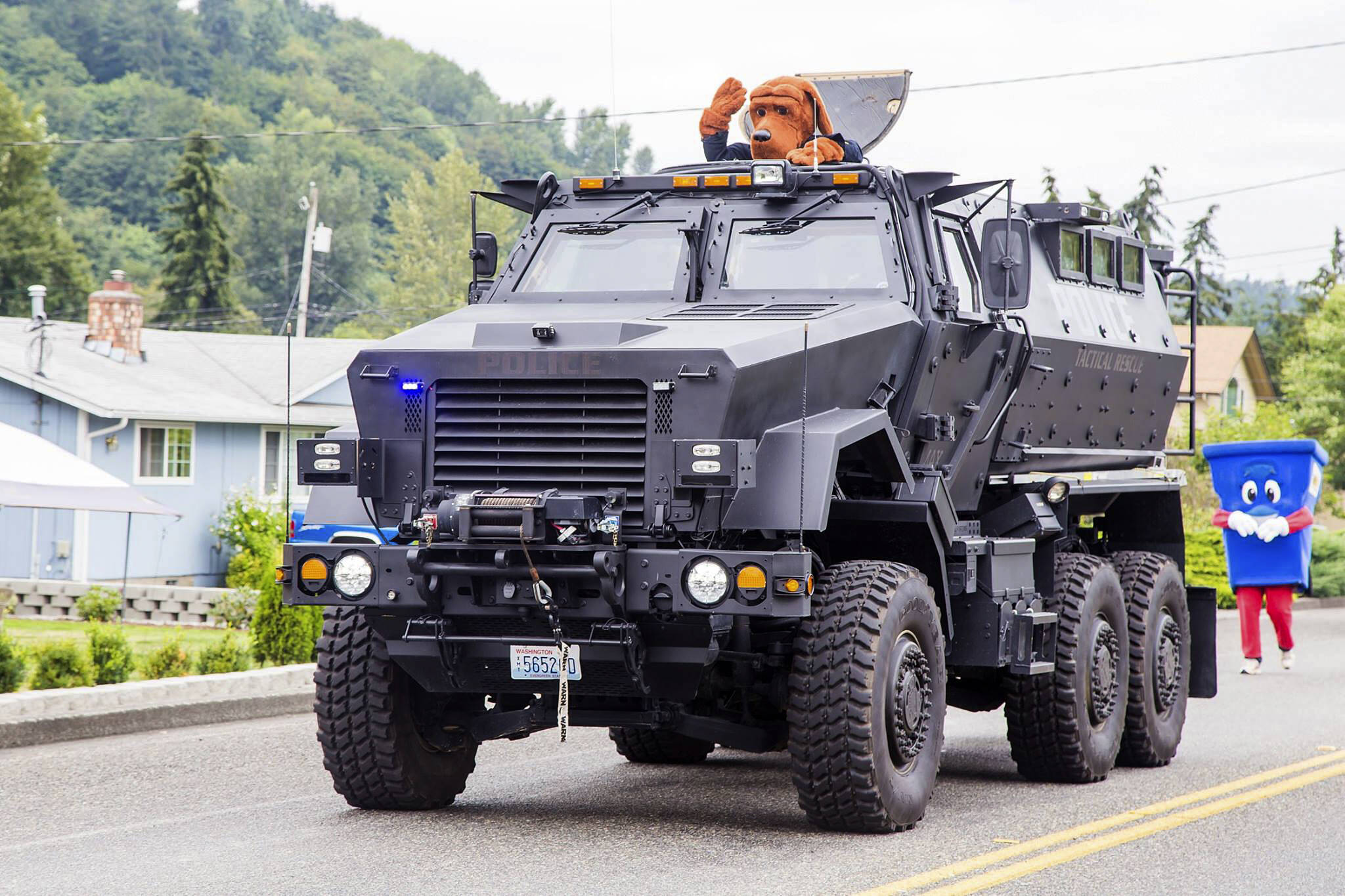 Snoqualmie Police Department houses a surplus military mine-resistant armored personnel carrier. They acquired it as part of an equipment sharing program from the federal government. It is utilized by a coalition of small-city police departments. It is seen here during a 2016 parade in Algona, one of the coalition member cities. From the Algona Police Department Facebook page