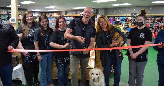 Owners Chris and Amy Hawkins (center) celebrate the 15 year anniversary and grand re-opening of Pet Place Market in North Bend on April 20, alongside staff and their dogs: Nala (l) and Jazzy. Photo Conor Wilson/Valley Record.