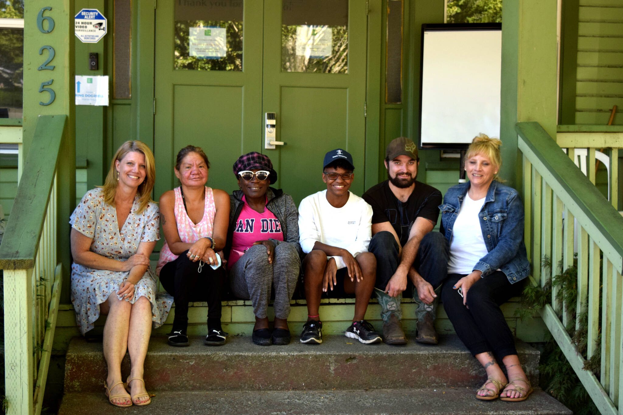 Conor Wilson / Valley Record
Jennifer Kirk (left), the executive director of Snoqualmie Valley Shelter Services, sits with shelter residents and staff on the steps of their downtown shelter. The Snoqualmie Valley Shelter Services Reclaiming Stability Luncheon will take place 11 a.m. to 12:30 p.m. Thursday, Sept. 15, at Meadowbrook Farm in North Bend.