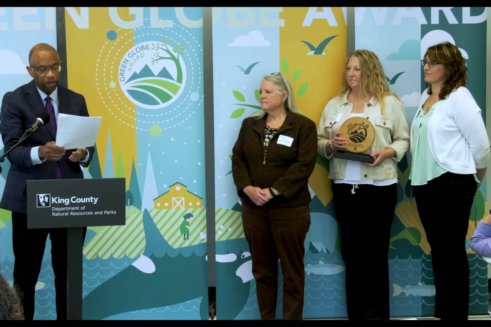 MC Essex Porter speaks about the Fish Farm Flood Oversight Committee. From left: Porter, Bobbi Lindemulder, Cindy Spiry and Angela Donaldson. Courtesy photo.