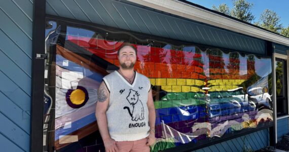 Axton Burton stands with their Intersex-Inclusive Progress Pride flag ribbon art in downtown Duvall on June 9, 2024. Photo by Grace Gorenflo