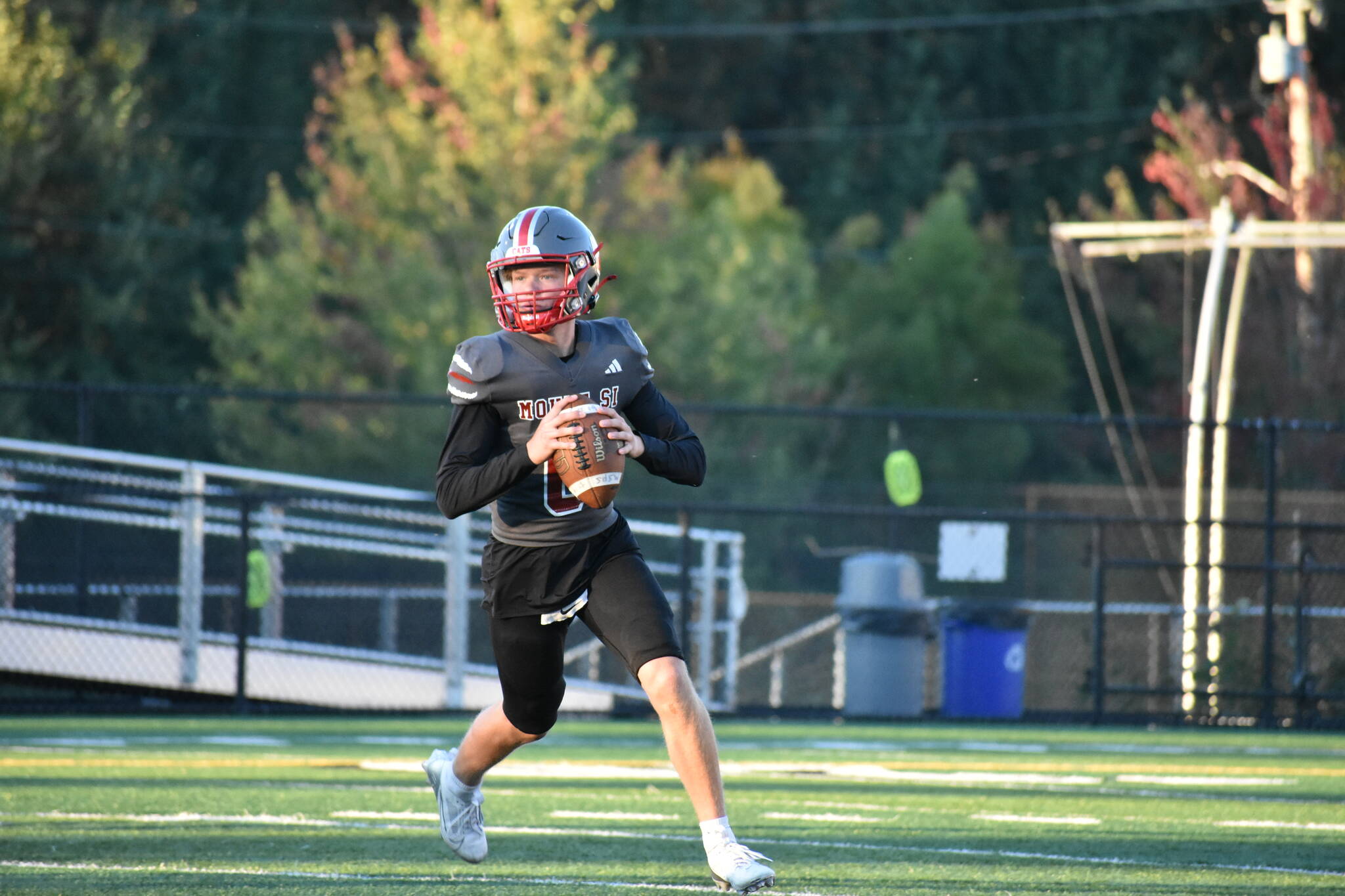 Mount Si quarterback rolls outside the pocket during a simulated drill.