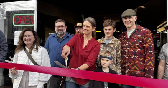 Christeena Marzolf prepares to cut a celebratory ribbon with family and friends at Falling River Meats Oct. 17, 2024. From left: Valerie Pacheco, Snoqualmie Valley Chamber of Commerce board secretary; Justin Fitch, Falling River Meats chef; Christeena Marzolf, Falling River Meats co-owner; Marcus Marzolf; Rowan Marzolf; Darron Marzolf, Falling River Meats co-owner. (Photo by Grace Gorenflo/Valley Record)