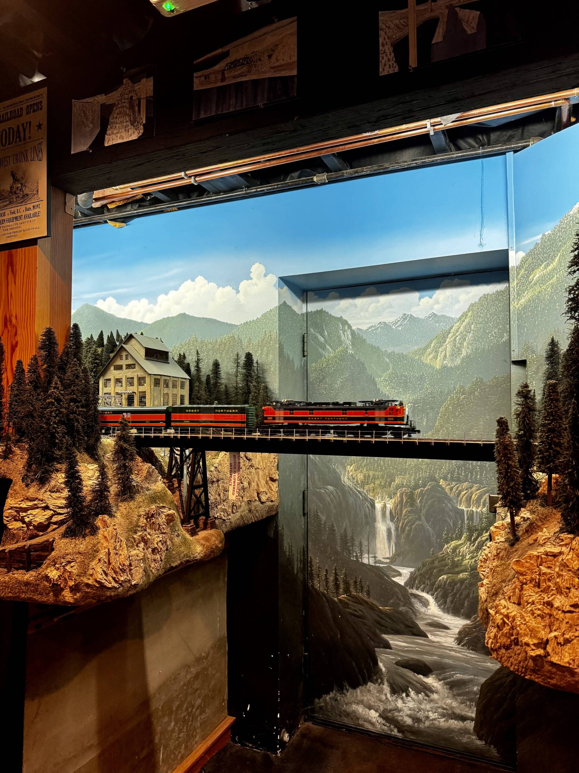 A model train crosses a bridge in front of the exterior door to Peter Hambling’s basement. The basement was built for this project.