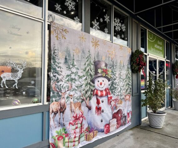 Duvall Advanced Family Eye Care’s windowscape includes Christmas-themed tapestries and other decor. (Grace Gorenflo/Valley Record)